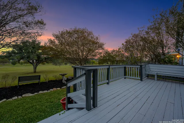 a view of a deck with chairs and a yard with wooden floor