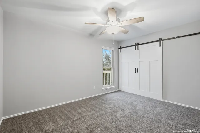 a view of empty room with a ceiling fan