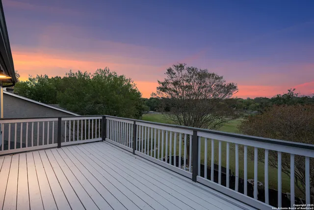 a balcony with wooden floor and fence