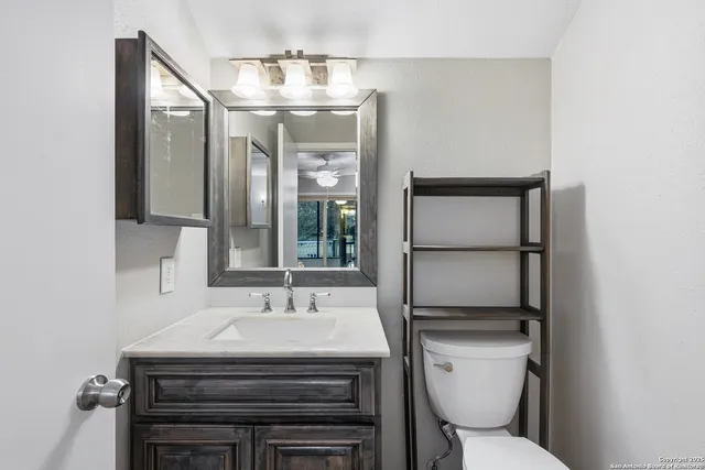 a bathroom with a toilet a sink and mirror