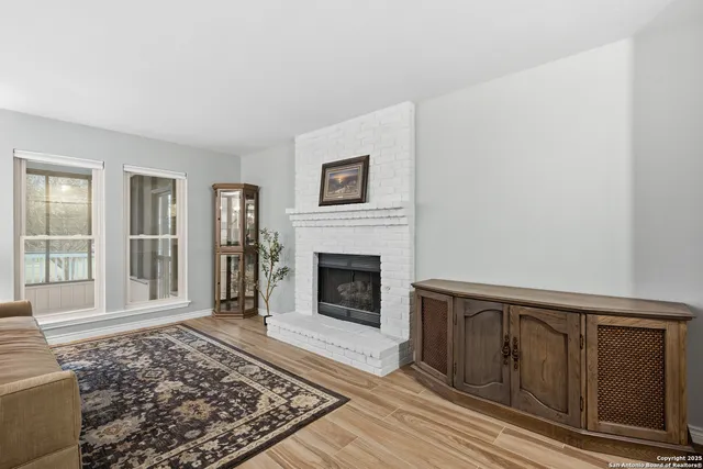 a view of a livingroom with wooden floor and a fireplace