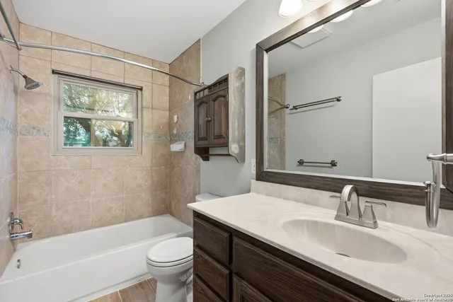 a bathroom with a granite countertop sink toilet and shower