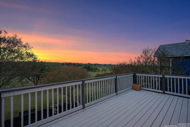 a view of a balcony with wooden floor and fence