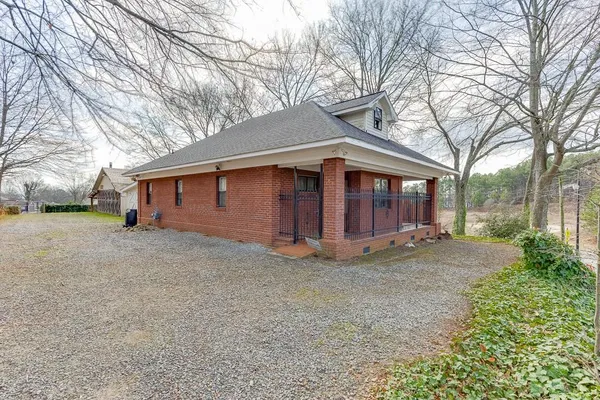 a view of a house with a yard and large tree