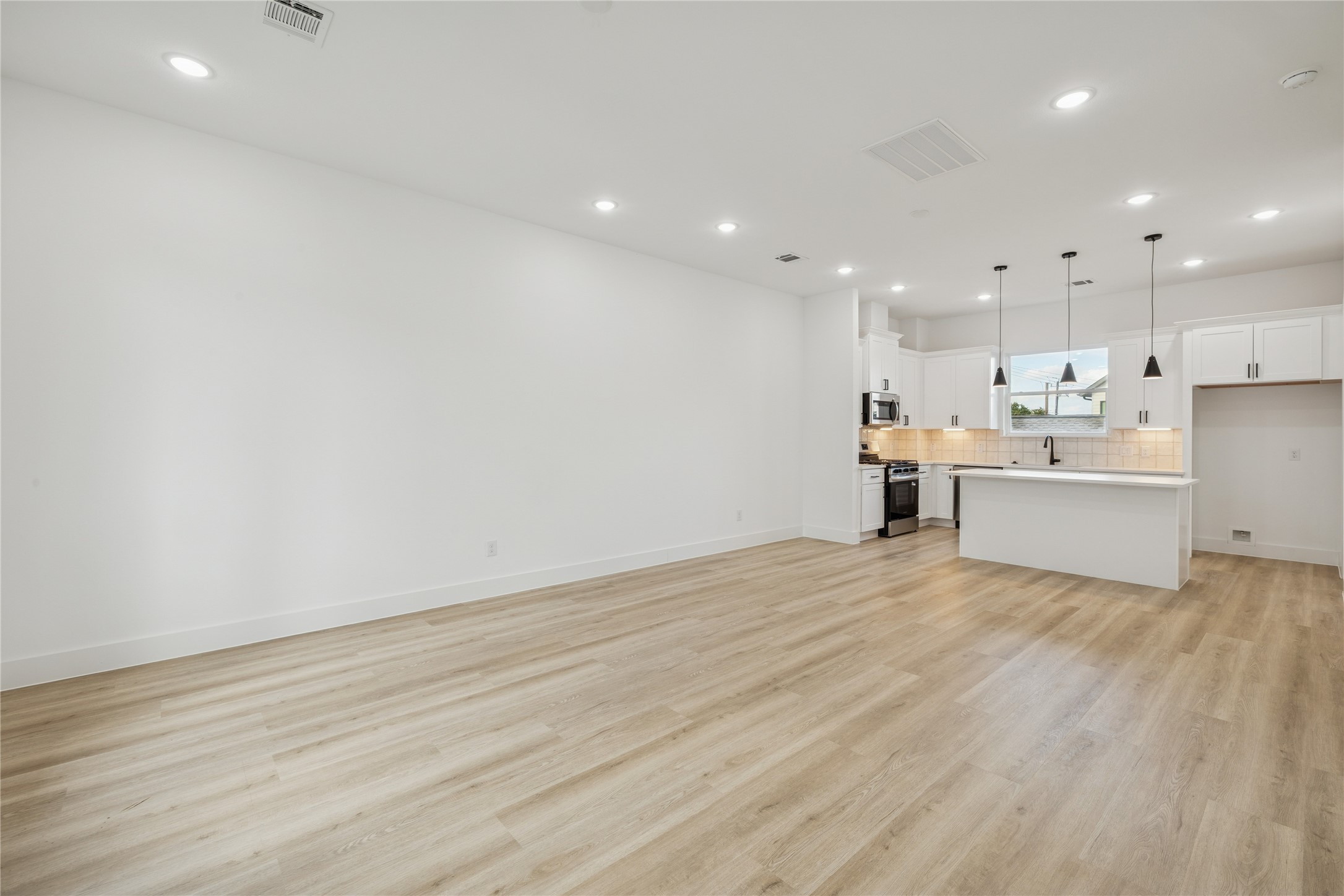 111 Milby Street Houston, TX 77003 - Photo 10 of 34 a view of a kitchen with wooden floor and stainless steel appliances