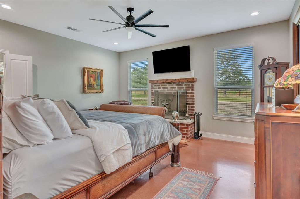 129 Whiskey Rnch Road Runaway Bay, TX 76426 - Photo 20 of 39 a bedroom with a large bed a flat screen tv and dresser