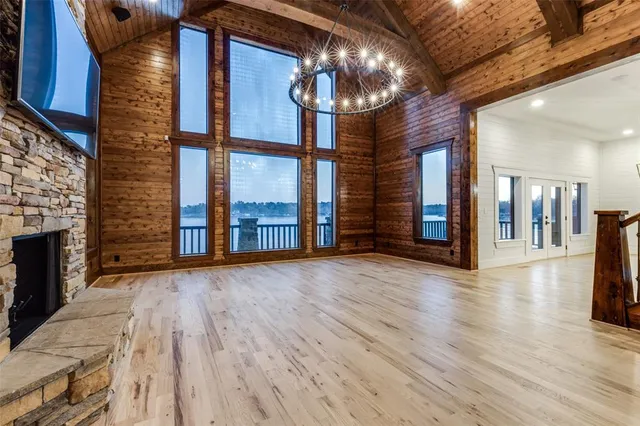 a view of an empty room with wooden floor and a fireplace