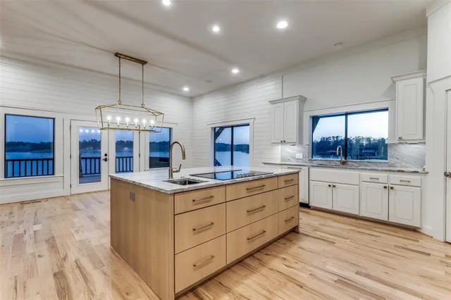 a large kitchen with stainless steel appliances kitchen island a large counter top and a wooden floors