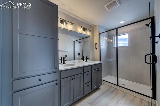 a bathroom with a double vanity sink mirror and shower