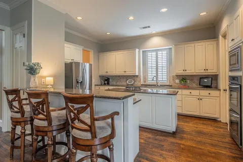 a kitchen with cabinets a sink a window and chairs