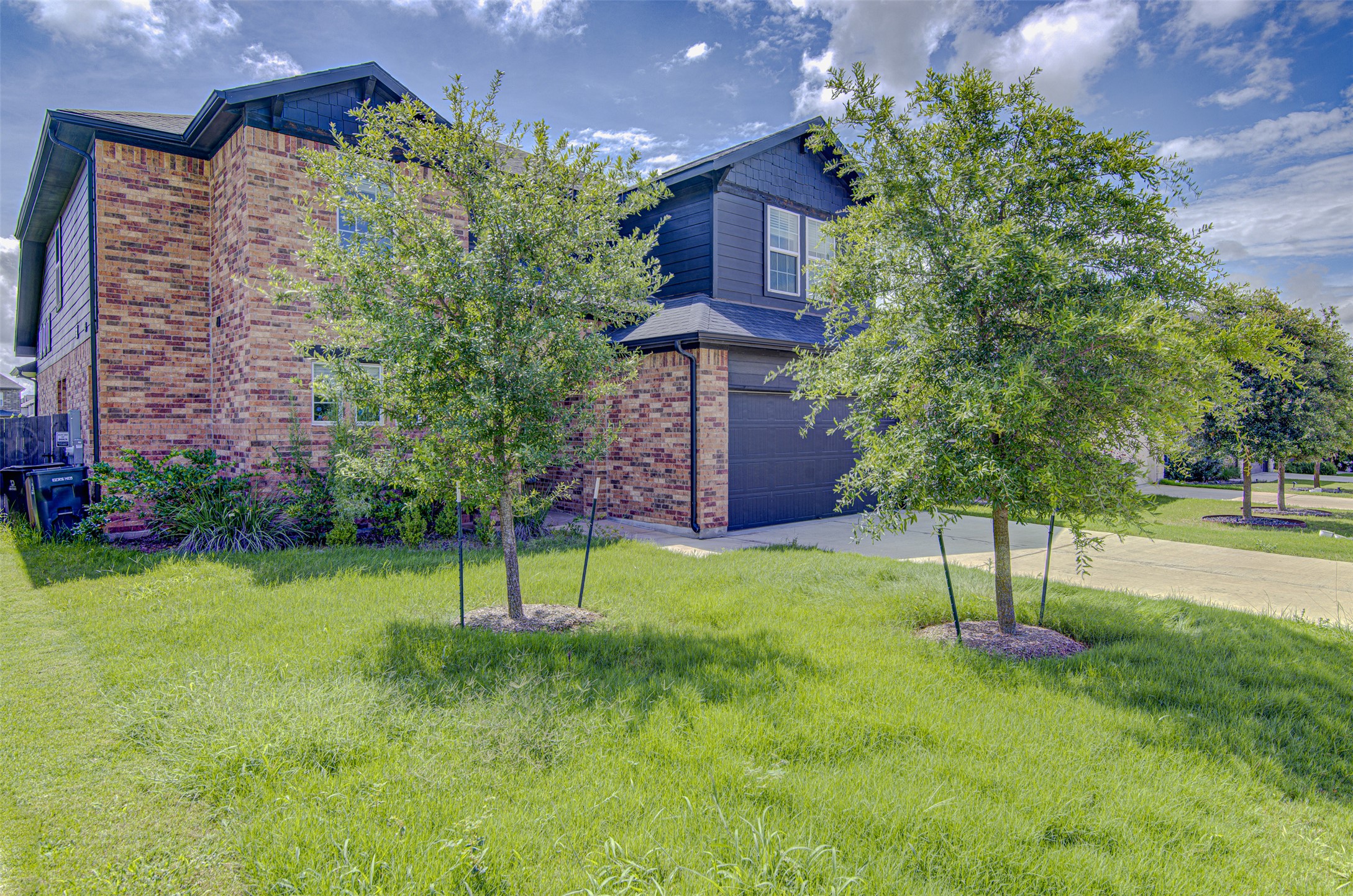 774 Cherrystone Loop Buda, TX 78610 - Photo 3 of 38 A well-maintained lawn introduces this inviting property with brick and siding details.