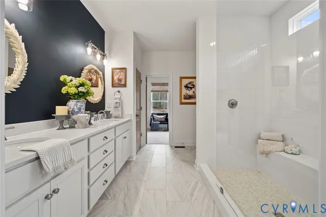a bathroom with a double vanity sink mirror and shower