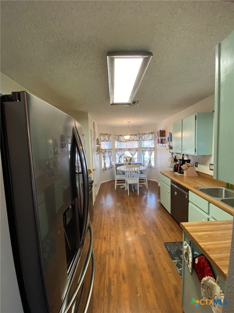 8305 Fort Sumter Road Austin, TX 78745 - Photo 16 of 23 a kitchen with stainless steel appliances granite countertop a refrigerator a stove and a wooden floors