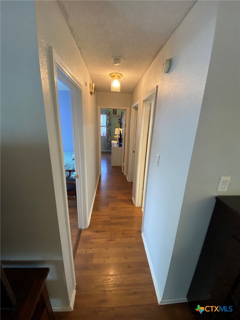 8305 Fort Sumter Road Austin, TX 78745 - Photo 19 of 23 a view of a hallway with wooden floor and staircase