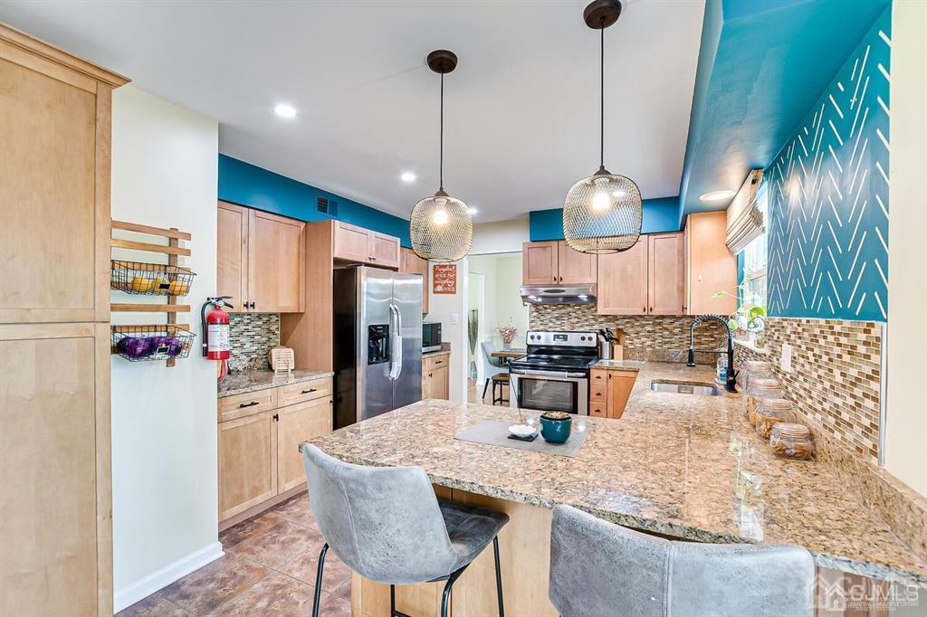 127 Hickory Road Somerset, NJ 08873 - Photo 19 of 51 a kitchen with stainless steel appliances kitchen island granite countertop a table and chairs in it