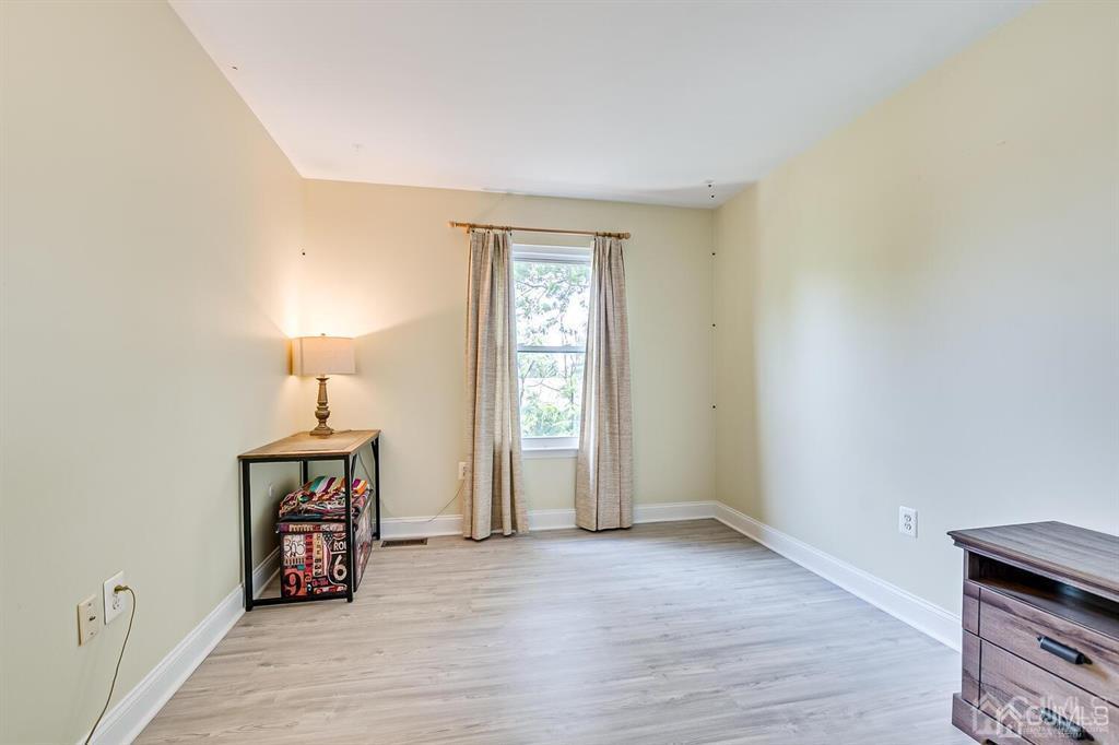 127 Hickory Road Somerset, NJ 08873 - Photo 29 of 51 a view of an empty room with wooden floor and a window