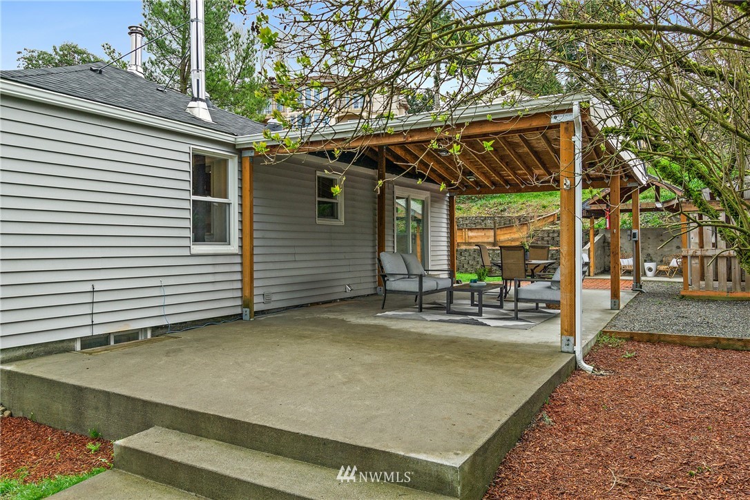 466 Grandey Way Northeast Renton, WA 98056 - Photo 16 of 21 a view of a patio with table and chairs potted plants and a large tree