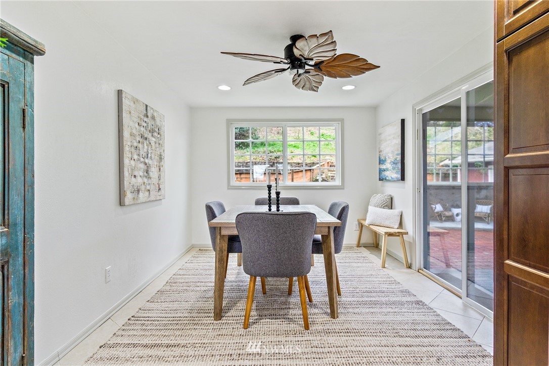 466 Grandey Way Northeast Renton, WA 98056 - Photo 8 of 21 a dining room with wooden floor a chandelier a glass table and windows