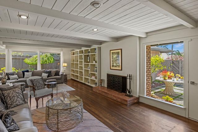 a living room with fireplace furniture and a floor to ceiling window