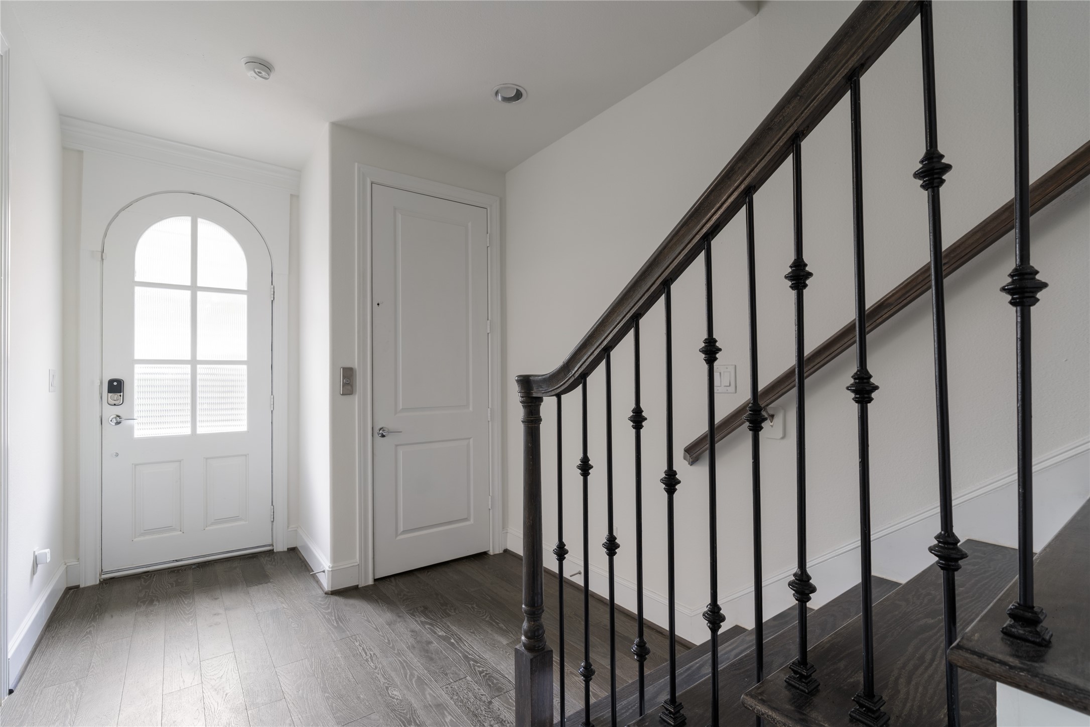 2613 Maxroy Street Houston, TX 77007 - Photo 33 of 43 The welcoming foyer is anchored by a striking arched front door and offers convenient access to multiple areas of the home, including a private bedroom ideal for guests or a home office.