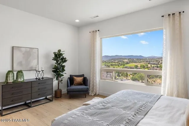 a bedroom with a bed dresser and a window