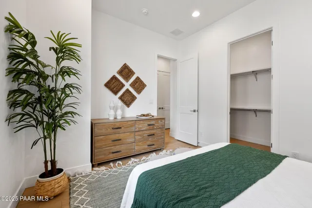 a bedroom with a bed and a potted plant