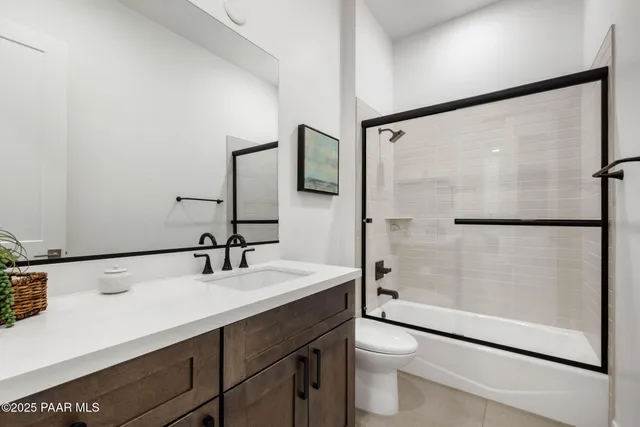 a bathroom with a double vanity sink toilet mirror and shower