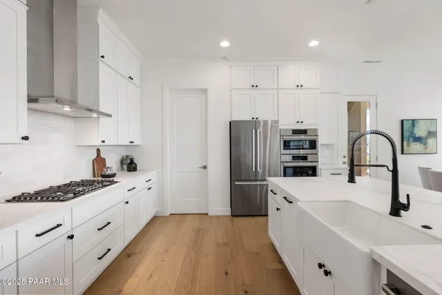 a kitchen with stainless steel appliances a refrigerator sink and white cabinets