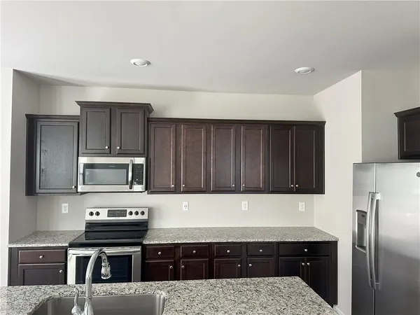a kitchen with a refrigerator and a stove top oven