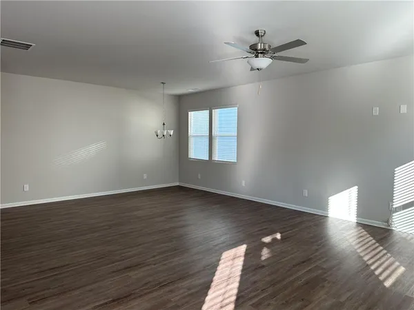a view of a livingroom with wooden floor and a ceiling fan