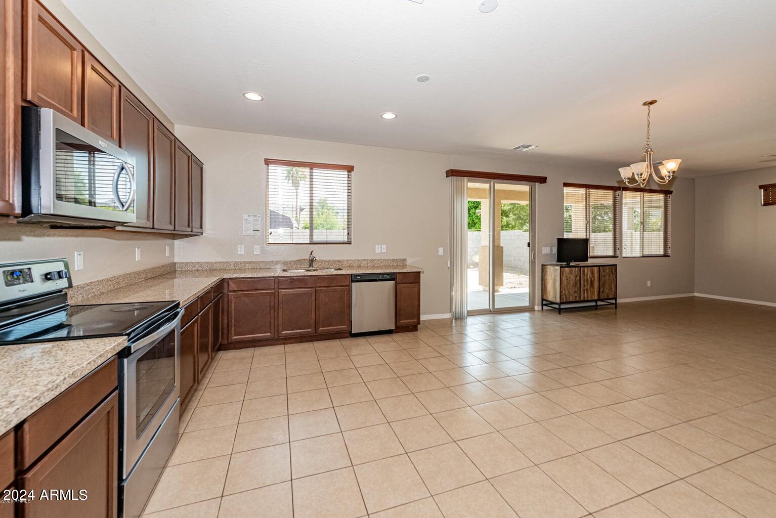 2729 East Dunbar Drive Phoenix, AZ 85042 - Photo 11 of 29 a large kitchen with stainless steel appliances granite countertop a sink and cabinets