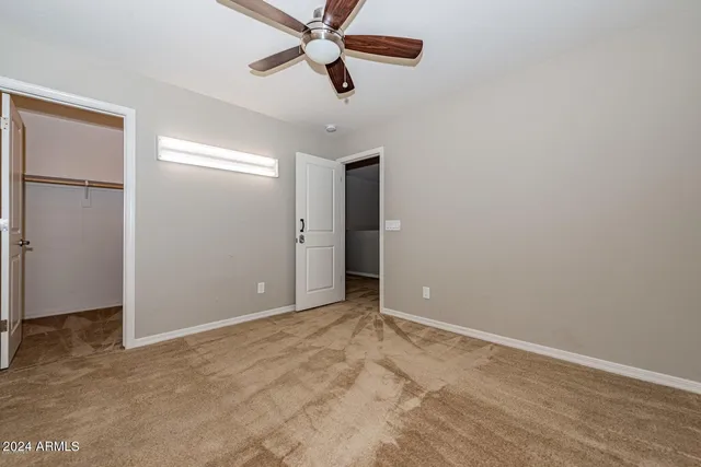 an empty room with closet and windows