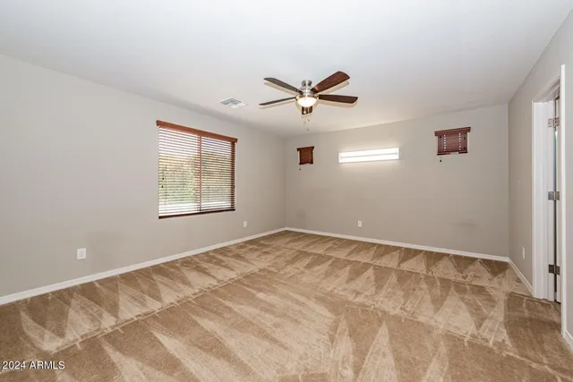 a view of empty room with ceiling fan
