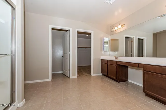 a large bathroom with a double vanity sink a large mirror and a bathtub