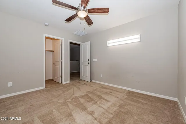 an empty room with chandelier fan