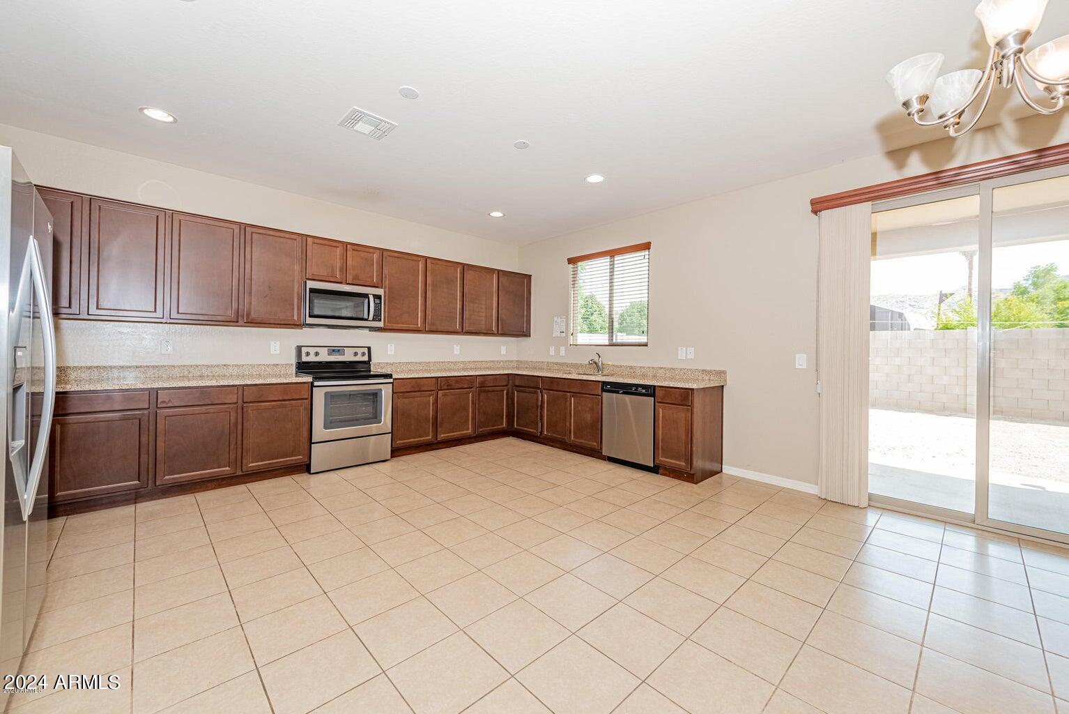 2729 East Dunbar Drive Phoenix, AZ 85042 - Photo 9 of 29 a kitchen with stainless steel appliances a cabinets and a refrigerator