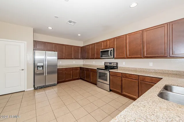 a kitchen with stainless steel appliances granite countertop a refrigerator and a sink