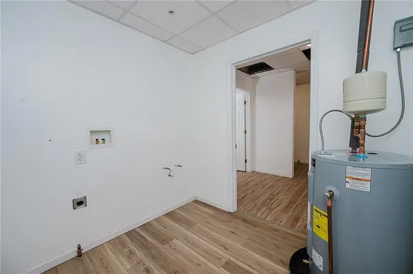 an empty room with wooden floor a ceiling fan and windows