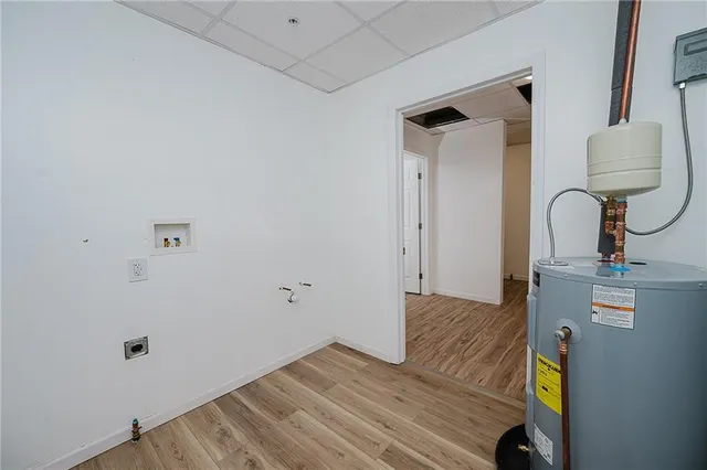 an empty room with wooden floor a ceiling fan and windows
