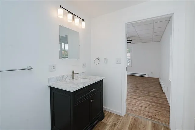a bathroom with a granite countertop sink toilet a mirror and shower