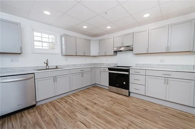 a view of empty room with wooden floor
