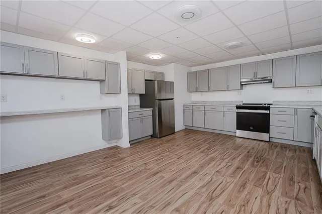 a kitchen with a sink cabinets stainless steel appliances and a window