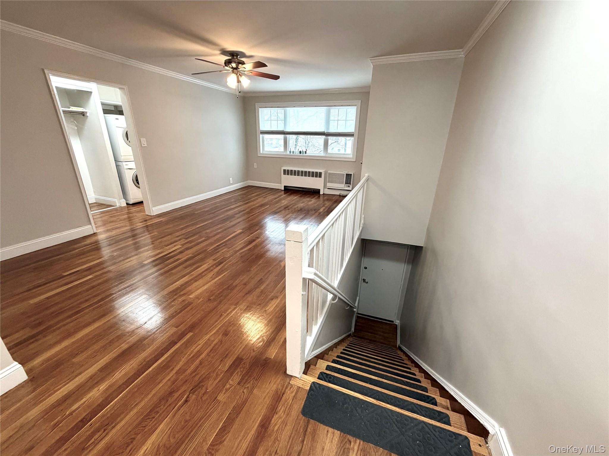 77-17 Springfield Boulevard, Unit 98 Queens, NY 11364 - Photo 4 of 18 a view of an empty room with wooden floor fridge and a window