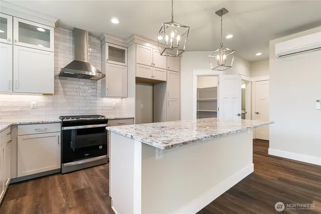 a kitchen with stainless steel appliances granite countertop wooden floors and white cabinets