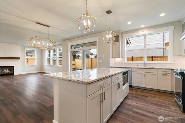 a kitchen with stainless steel appliances granite countertop a stove refrigerator and cabinets