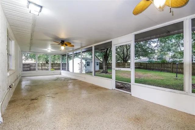 a view of an empty room with a floor to ceiling window and yard