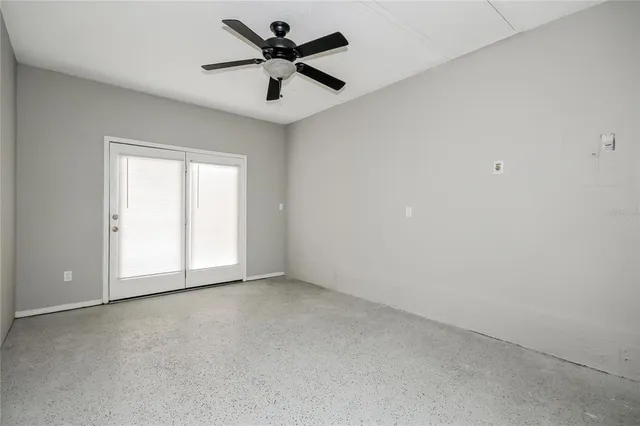 an empty room with a window and a fan