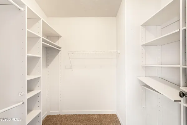 a view of walk in closet with empty racks