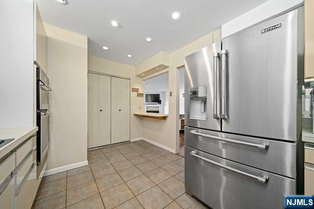 1225 River Road, Unit 6A Edgewater, NJ 07020 - Photo 12 of 30 a kitchen with stainless steel appliances a refrigerator and cabinets