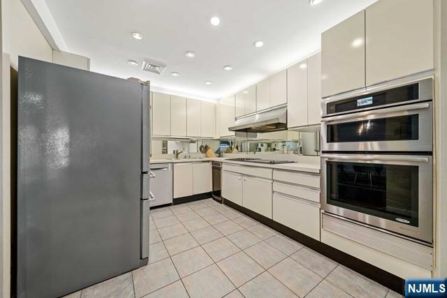 1225 River Road, Unit 6A Edgewater, NJ 07020 - Photo 14 of 30 a kitchen with a sink stainless steel appliances and cabinets